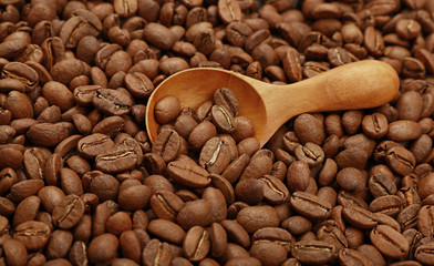 Wooden scoop with roasted coffee beans