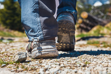 hiker walking on path in the mountains. Close up of shoes