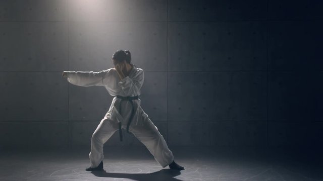 Young woman in kimono practicing karate. Slow motion