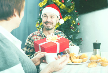 Mother and son exchanging Christmas gifts