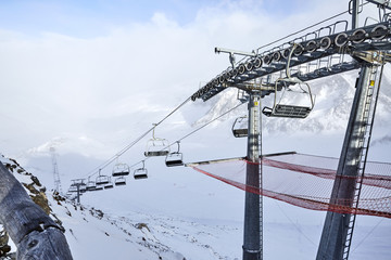 Funicular on top of the mountain in winter. Chair alpine skiing lift. The line of the skiing lift...