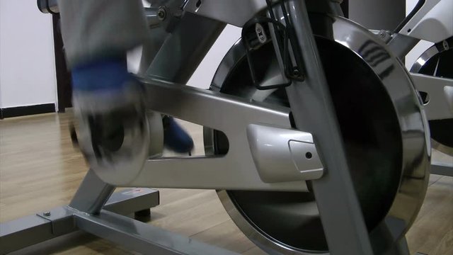A man is riding a bike in the gym