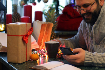 beard man writing christmas gifts on a table
