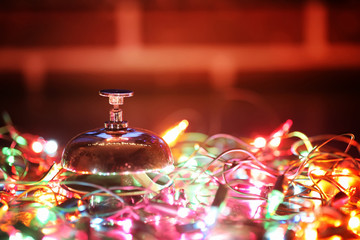 reception bell on table and color shining garland on background