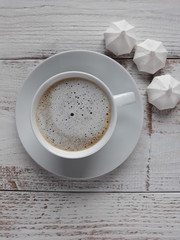 a cup of coffee and small meringues