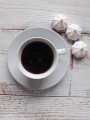 a cup of coffee and small meringues