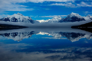 Fototapeta na wymiar Lake fog reflection in winter Lake McDonald, Glacier National Park, Montana blue sky