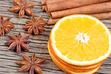 Obraz na płótnie Canvas Sliced of dried orange with cinnamon sticks and anise on table
