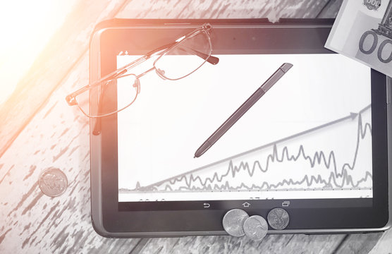 The graph of income growth. Electronic tablet with a graph of gr