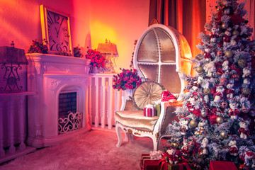 New Year's holidays. A decorated Christmas tree stands near the fireplace. Christmas tree with red ornaments. New Year holiday.