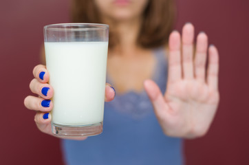 Ótimo conceito de intolerância a lactose, leite. Jovem mulher negando copo de leite.