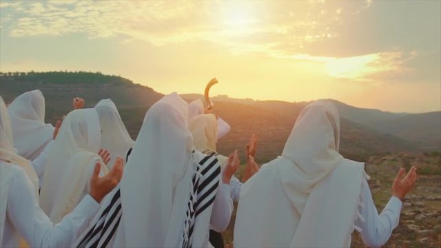 Jewish men prayer With Talit and shofar in sunset