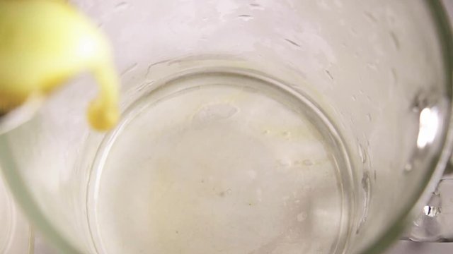 Fresh squeezed apple juice is poured into a glass in slow motion