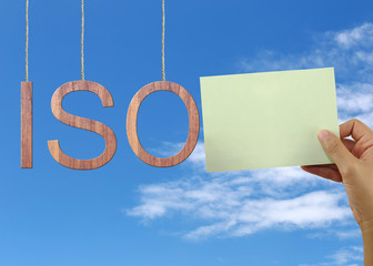 Wooden ISO text Stands for International Organization for Standardization hanging on rope.