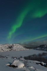 Fototapeta na wymiar Northern lights ,aurora over the hills and lake ice.