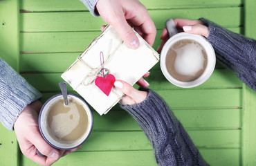 Couple drinking hot coffee at wooden table on a date
