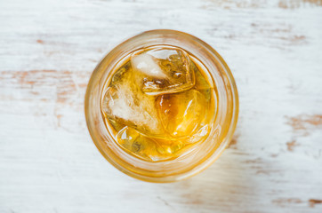 Glass with whiskey on the rustic wooden background. Selective focus. Shallow depth of field.