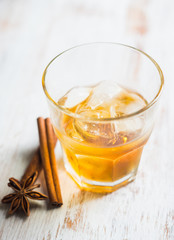 Glass with whiskey on the rustic wooden background. Selective focus. Shallow depth of field.