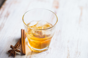 Glass with whiskey on the rustic wooden background. Selective focus. Shallow depth of field.