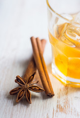 Glass with whiskey on the rustic wooden background. Selective focus. Shallow depth of field.