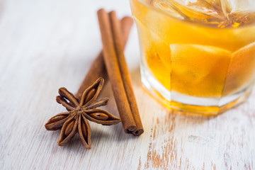 Glass with whiskey on the rustic wooden background. Selective focus. Shallow depth of field.