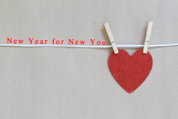 Red heart hanging on a rope and have New year for New you text.