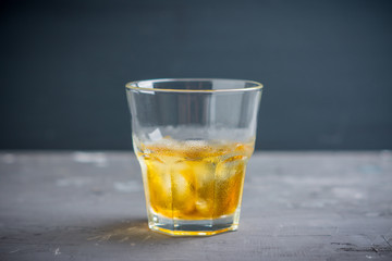 Glass with whiskey on the rustic wooden background. Selective focus. Shallow depth of field.