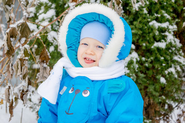 Happy baby boy is glad to snow - winter holiday outing for children