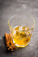 Glass with whiskey on the rustic wooden background. Selective focus. Shallow depth of field.