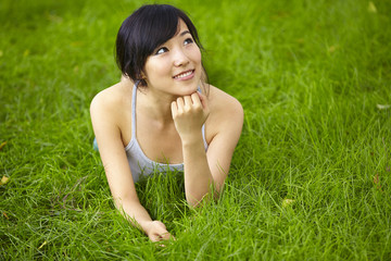 Naklejka na ściany i meble pretty young asian woman relax on grassland