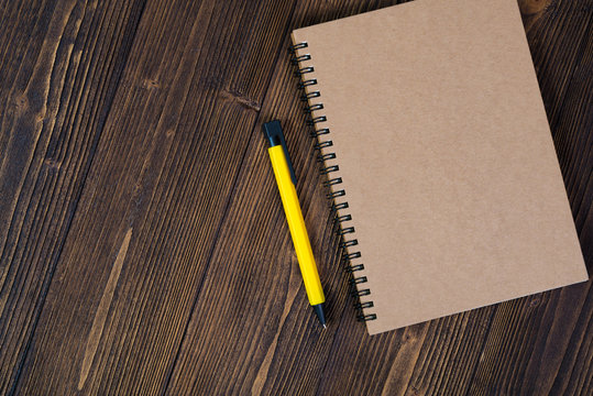 Notebook with pen on wood table top view with copy space