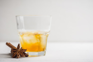 Glass with whiskey on the rustic wooden background. Selective focus. Shallow depth of field.