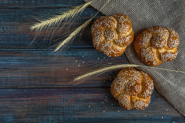 Buns with sesame seeds on a wooden background top view