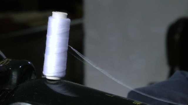 An old man is operating a sewing machine