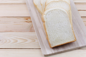Sliced bread Stacked on a wooden chopping board.