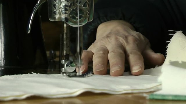 An old man is operating a sewing machine