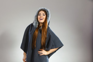 Happy woman wearing dark poncho with hood