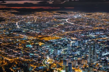 Stoff pro Meter Südamerika Bogota, Kolumbien, Blick auf die Innenstadt von Gebäuden und das Stadtbild, das in der Abenddämmerung beleuchtet wird.