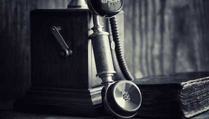 Old telephone and retro book on the desk. The phone of the past 