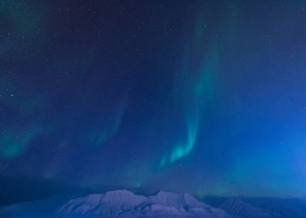 Naklejka na ściany i meble The polar arctic Northern lights aurora borealis sky star in Norway Svalbard in Longyearbyen city the moon mountains