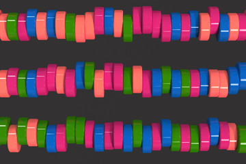 Fototapeta premium Pattern of blue, red and green cylinder tablets on black background