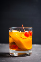 Old fashioned cocktail with cherry and orange. Selective focus. Shallow depth of field.