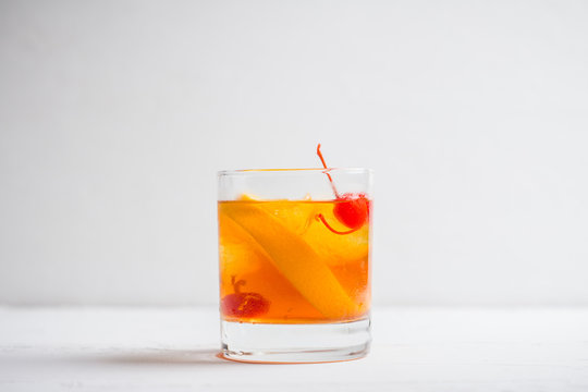 Old fashioned cocktail with cherry and orange. Selective focus. Shallow depth of field.