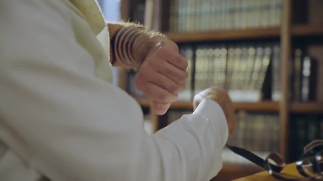Jewish man put on  the hand a tefillin