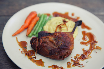 duck confit , Grilled duck steak with carrot and asparagus on wood background