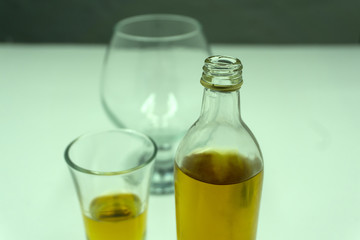 Cognac. drinking brandy from the bottle into a glass in the background .