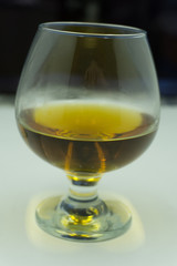 Scotch on wooden background with copyspace. An old and vintage countertop with highlight and a glass of hard liquor .