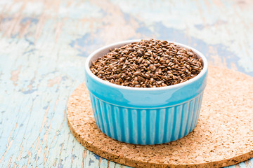 Fototapeta na wymiar Flax seeds in a bowl on a wooden table