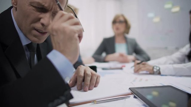 Business worker feeling bad headache at meeting, work frustration and stress