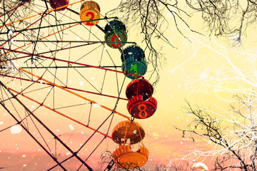 New year 2018. Two thousand eighteen. Ferris wheel. Naked trees under a snowfall against sunrise...